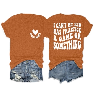 Flat lay of terracotta orange t-shirt with slogan print and distressed blue denim shorts
