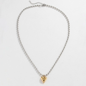 Polished stainless steel beaded necklace with gold heart pendant on white textured background