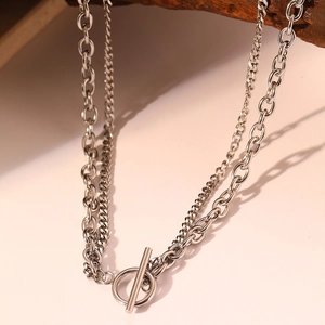 Close-up of silver double-layered chain necklace featuring a vintage OT toggle clasp