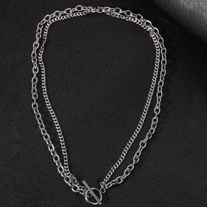 Detail of silver double-layered chain necklace featuring chunky links and OT toggle clasp