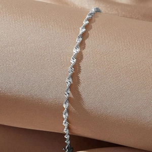 Elegant 18K gold-plated stainless steel water wave chain bracelet on champagne silk satin