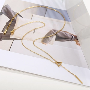 Detailed view of golden lariat necklace with geometric triangle and vertical bar pendant