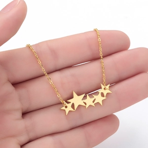 Gros plan d'un collier à pendentifs étoiles dorées montrant la texture fine du métal
