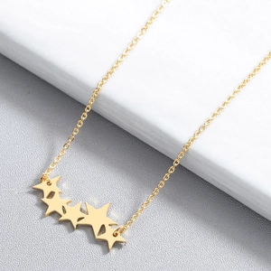 Gros plan détaillé du collier doré en acier inoxydable avec pendentif étoile sur marbre