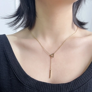Gold-plated stainless steel Y-necklace with triangle and bar pendants on female model