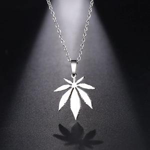Detailed close-up of maple leaf pendant on chain with sharp lighting and shadows