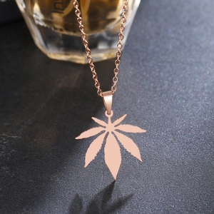 Bohemian rose gold maple leaf necklace pendant in stainless steel on a dark textured background