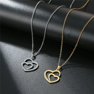 Close-up of gold and silver stainless steel double heart pendant necklaces with link chain