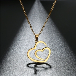 Elegant gold double heart pendant necklace with hollow design on textured grey background