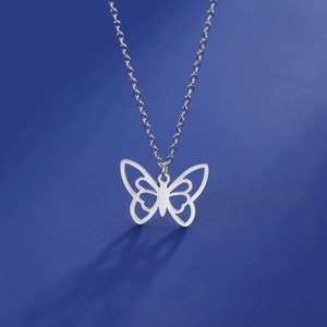 Vue détaillée du pendentif papillon évidé sur une fine chaîne en acier inoxydable argenté