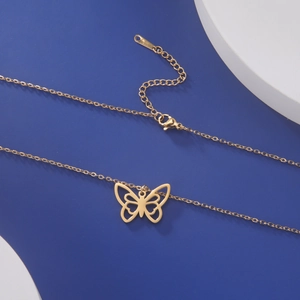 Détail du collier à pendentif papillon doré avec design ajouré et fermoir mousqueton