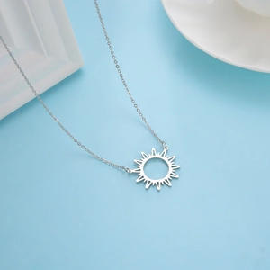 Collier soleil ajouré minimaliste en acier inoxydable sur plateau en céramique
