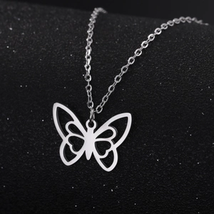 Collier avec pendentif papillon évidé en acier inoxydable poli sur fond noir texturé