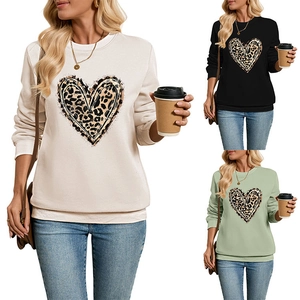 Close-up of leopard heart print sweatshirts in beige, black, and sage green colors