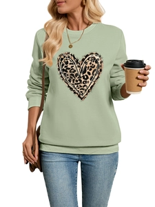 Detail of light green sweatshirt with leopard heart print and ribbed cuffs