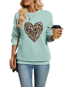 Close-up of mint blue sweatshirt featuring a bold leopard print heart and ribbed cuffs
