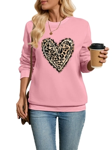 Detail of pink sweatshirt featuring leopard print heart pattern on urban casual model