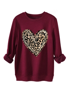 Detail of burgundy sweatshirt featuring leopard heart print and soft fleece inner texture