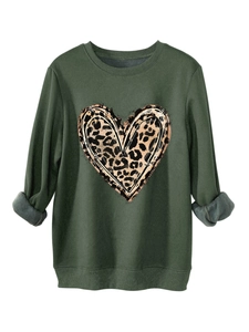 Detail of dark green sweatshirt featuring a leopard print heart and cozy fleece texture