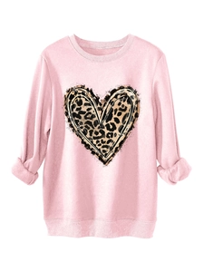 Detail of pink sweatshirt featuring leopard heart print with artistic ink stroke edges