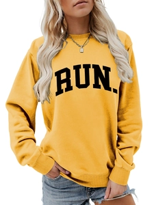 Detail of loose yellow sweatshirt featuring RUN letter print and ribbed cuffs for women