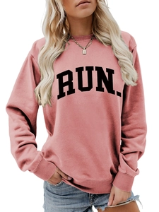 Detail of pink crewneck sweatshirt with black RUN lettering and ribbed cuffs