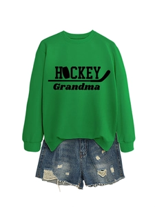 Mise à plat d'un sweat vert Hockey Grandma avec un short en jean sur fond blanc pur