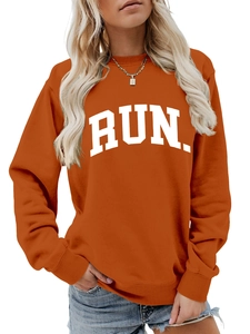 Detail of orange sweatshirt featuring white RUN. letter print and ribbed cuffs