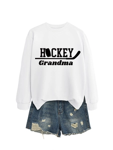 Mise à plat d'un sweat blanc Hockey Grandma et d'un short en jean bleu délavé
