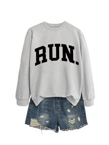 Flat lay of gray sweatshirt with black RUN print and distressed blue denim shorts
