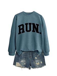 Detail of vintage blue crewneck sweatshirt featuring black RUN letters and ripped denim shorts
