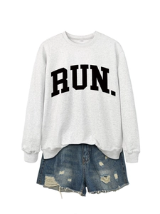 Detail of grey RUN letter sweatshirt paired with distressed blue denim shorts