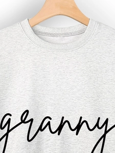 Detail of grey crewneck sweatshirt with black granny script and ribbed collar texture