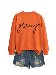 Close-up of granny script and heart print on bright orange crewneck sweatshirt