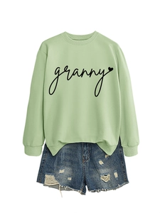 Detail of light green sweatshirt with granny heart print and blue distressed denim shorts