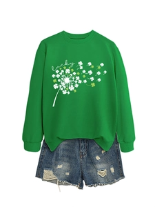 Dettaglio della stampa a trifoglio su felpa verde con pantaloncini in denim strappati