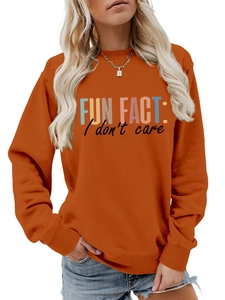 Gros plan sur le sweat-shirt orange brûlé avec l'imprimé FUN FACT I don't care