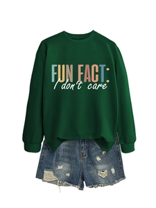 Détail du sweat vert foncé avec inscription et short en jean déchiré en ensemble décontracté