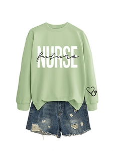 Detail of sage green sweatshirt with NURSE future print and distressed denim shorts