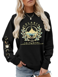 Close-up of the Velaris City of Starlight gold print on a black crewneck sweatshirt