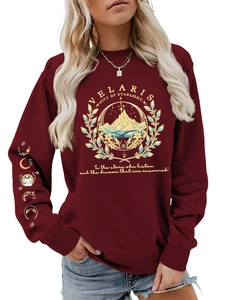 Detailed embroidery of mountains and moon phases on dark red sweatshirt sleeves