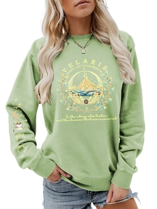 Detail of sage green sweatshirt featuring Velaris star emblem and sleeve moon phases