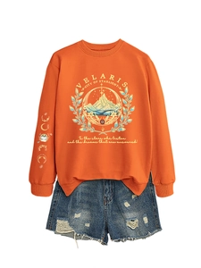 Detailed close-up of Velaris City of Starlight print on orange sweatshirt and denim shorts