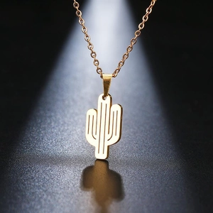 Macro view of gold stainless steel cactus pendant with hollow design on black texture