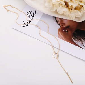 Platte weergave van een gouden Y-vormige lariatketting met ring en minimalistische bar