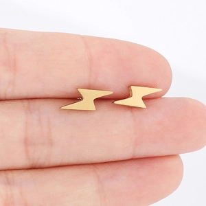 Pair of minimalist gold stainless steel lightning bolt stud earrings shown on fingers
