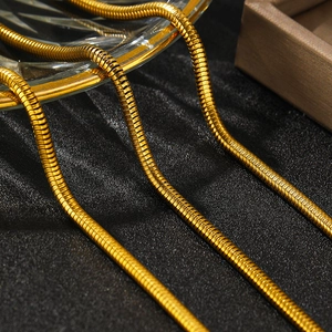 Chaîne serpent dorée polie de style cubain épais sur un fond de luxe sombre chic