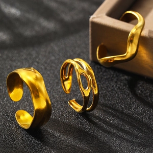 Detailed view of three irregular gold plated stainless steel rings with a lava texture