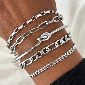 Dettaglio di bracciali a catena in argento a strati e un bracciale rigido al polso