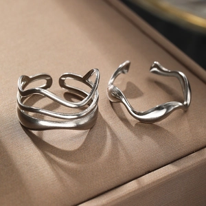 Macro shot of silver polished geometric wave rings with adjustable open band design